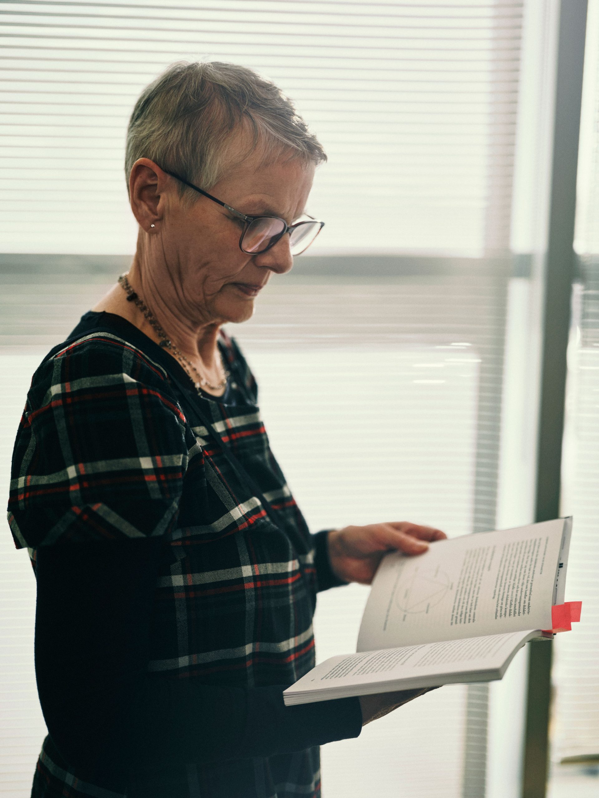 Caroline Liberg står och läser ur en bok.